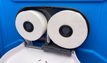 Two jumbo toilet rolls fitted to a portable toilet roll dispenser