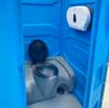 Inside view of a portaloo showing the holding tank and toilet roll dispenser